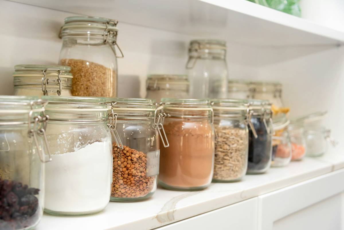 Glass-jarred organic plastic-free snacks lined up on a wooden shelf